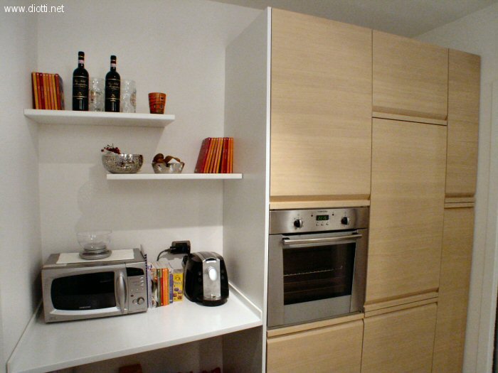 In questa immagine il piano d'appoggio in Corian, sagomato e sospeso, che si raccorda ad una spalla portante in laminato bianco di profondit 65: la sua funzione  sostenere il forno ed il contenitore superiore per fare in modo che non si appoggino alla lavatrice (visibile nelle foto qui sotto). Seguono la colonna frigo e la dispensa estraibile da 30 cm.